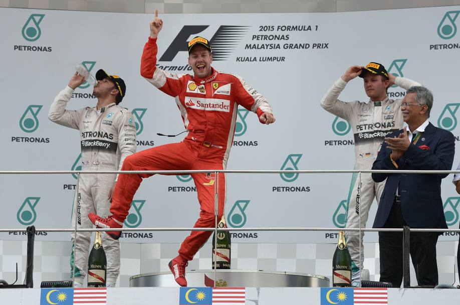 Sebastian Vettel incontenibile sul podio del Gran Premio della Malesia. Il tedesco della Ferrari ha dominato la gara sul circuito di Sepang, precedendo sul traguardo le due Mercedes del campione del mondo Lewis Hamilton e di Nico Rosberg (AFP)